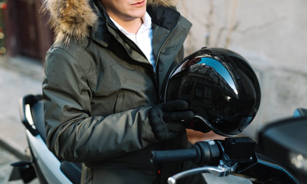 un homme avec un casque de scooter à la main