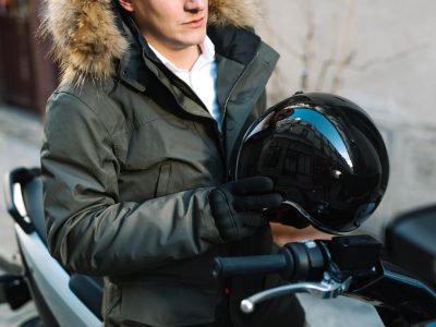 un homme avec un casque de scooter à la main