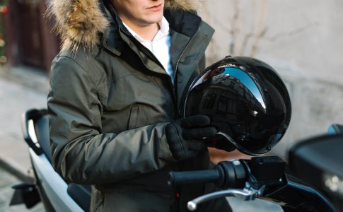 un homme avec un casque de scooter à la main